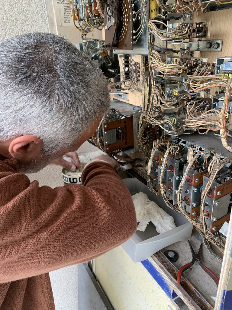 Laurent dans son atelier, au travail sur un flipper